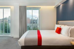 都柏林都柏林市中心快捷假日酒店的酒店客房设有一张带大窗户的床。