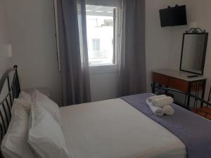 奥诺斯Asteri Hotel的一间卧室设有一张床、一个窗口和一台电视