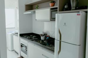 弗洛里亚诺波利斯Residencial Diva的白色的厨房配有炉灶和冰箱。
