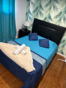 波尔图AL Pitões的一间卧室配有一张带蓝色床单和蓝色枕头的床。
