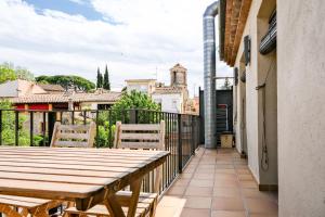 贝萨卢Ca lEudald 3 Apartamento en Besalú con terraza的阳台配有木桌和两把椅子