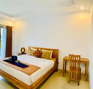 坎古Bali intan Canggu的卧室配有1张床、1张桌子和1把椅子