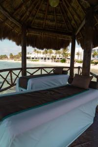 艾库玛尔Grand Oasis Tulum Riviera - All Inclusive的海滩上稻草伞下的两张床