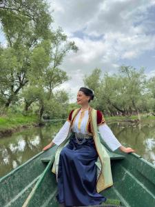 VranjinaApartment Dapcevic Skadar lake的坐在河边的船上的女人