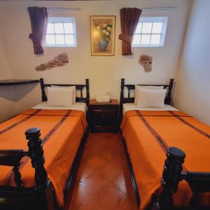 危地马拉安地瓜La Quinta Santa Lucia的带2扇窗户的客房内的2张床