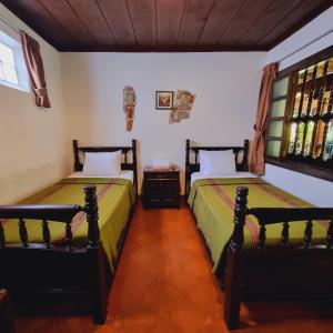 危地马拉安地瓜La Quinta Santa Lucia的一间卧室设有两张床和窗户。
