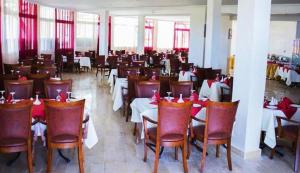 El KsibaHotel Angle Atlas的一间设有桌椅和红色弓的用餐室