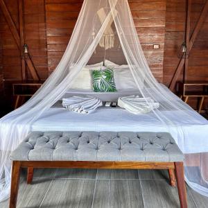 奥尔沃克斯岛Ecoco Holbox - EcoChic - Cabañas de Madera - Holbox Retreat的床上挂有蚊帐的床