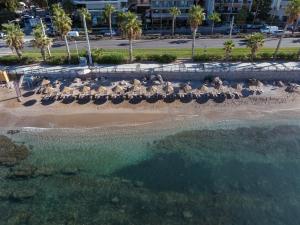 雅典雅典珊瑚酒店的享有海滩的空中景致,配有椅子和海洋