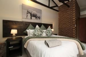 马里兰豪萨酒店的一间卧室配有一张大床,墙上挂着大象照片