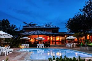 因巴塞Pousada Bichelenga的一个带椅子和遮阳伞的游泳池的度假酒店