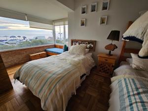 维纳德马Departamento Frente al Mar的一间卧室设有两张床和大窗户