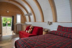 蒙泰克雷托Glamping Villaggio Parco Dei Castagni 4 stelle的一只泰迪熊坐在卧室的红色沙发上