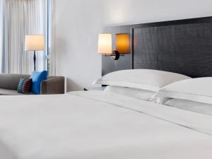 蒙特哥贝罗斯霍尔希尔顿温泉度假酒店的一张带白色床单和枕头的床