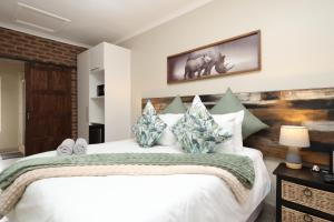 马里兰豪萨酒店的卧室配有带枕头的大型白色床