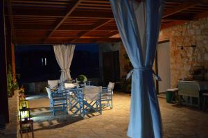 哈尔基岛Villa Romanza beach villa的配有桌椅和蓝色窗帘的房间