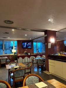佩斯卡拉玛雅酒店的餐厅设有桌椅和平面电视。