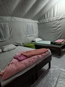 乌德尔格希Hill dew homestay的一间设有两张床的房间和一张帐篷内的桌子