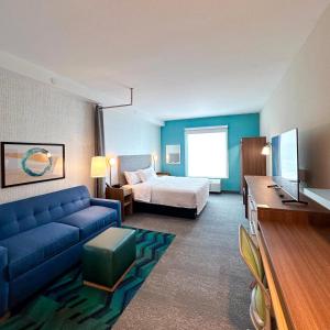 沃尔顿堡滩Home2 Suites By Hilton Fort Walton Beach的酒店客房配有蓝色的沙发和床。