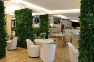 戛纳维多利亚酒店的餐厅设有白色的桌椅和绿色的墙壁