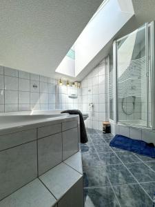 斯皮特安德劳Stadt & See Appartement Penthouse inkl MIC Card的带浴缸、水槽和淋浴的浴室