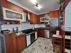 拉赫Apartamento Xanela o Mar的一间带木制橱柜的厨房和一台墙上的电视