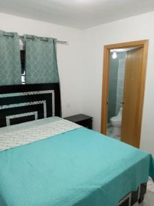 LiceyApartamento Amublado con piscina的一间卧室配有一张床,浴室设有卫生间