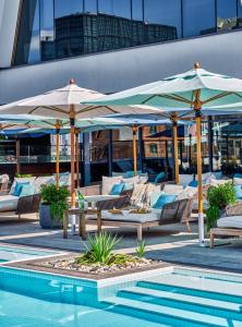 布鲁克林威廉河谷酒店的一组椅子和遮阳伞,位于游泳池旁
