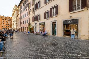 罗马Luxury Apartments Pantheon Roma的一条鹅卵石街道上,街上有一群人走着