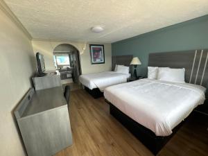 加尔维斯敦Econo Lodge Galveston Seawall的酒店客房设有两张床和电视。
