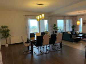 NemesbükkBalatonview - villa Myriam的客厅设有餐桌和椅子