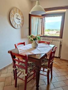 苏尔莫纳Il Bagolaro Casa Vacanze的餐桌、椅子和墙上的时钟