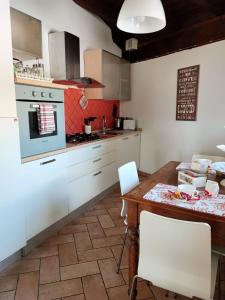 苏尔莫纳Il Bagolaro Casa Vacanze的厨房配有白色橱柜和木桌