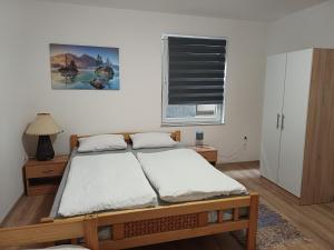 亚伊采Rose Apartmans的一间卧室设有一张床和一个窗口