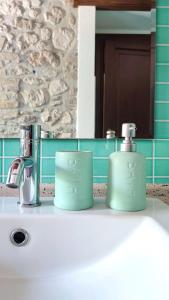 苏尔莫纳Il Bagolaro Casa Vacanze的浴室水槽上坐着两个绿杯