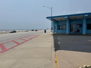 加尔维斯敦Econo Lodge Galveston Seawall的蓝色建筑旁边的空停车位