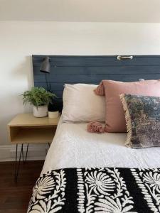 皮克顿Hill Street Hangout的一张带蓝色床头板的床和一张带枕头的桌子