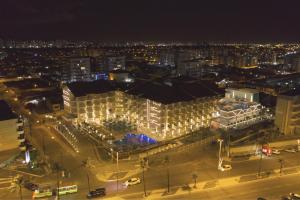 阿拉卡茹Vidam Hotel Aracaju - Transamerica Collection的享有带灯的大型建筑的夜景