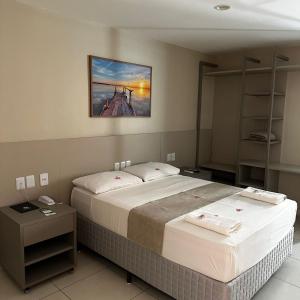 劳鲁-迪弗雷塔斯奥尼克斯机场酒店的卧室配有两张床,墙上挂着一幅画