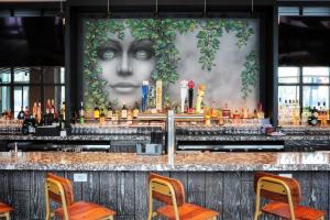 芝加哥Le Meridien Essex Chicago的带有一幅女人大壁画的酒吧
