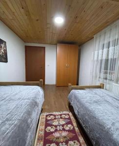 佩奇Villa Albani的一间卧室设有两张床和木制天花板