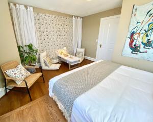 那诺斯湾Gorgeous Private Estate With Ocean and Mountain View的卧室配有白色的床和桌椅