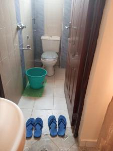 内罗毕Gloria House的浴室设有卫生间和一双蓝鞋