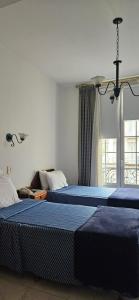 布宜诺斯艾利斯阿斯托利亚酒店的一间卧室设有两张床和窗户。