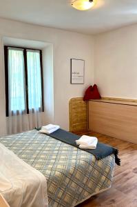 加尔达湖滨瓦拉内酒店的一间卧室配有一张床,上面有两条毛巾