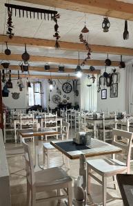 加尔达湖滨瓦拉内酒店的用餐室配有木桌和白色椅子