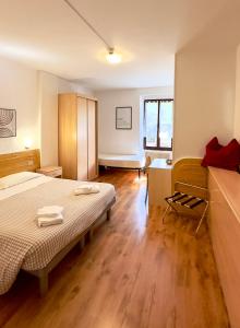 加尔达湖滨瓦拉内酒店的一间卧室配有一张床、一张书桌和一个窗户。