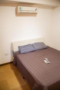 加拉加斯Apartamento Av Andres Bello的一间卧室配有一张床和一个带遥控器的窗户