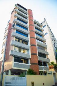 加拉加斯Apartamento Av Andres Bello的一座高大的砖砌建筑,有蓝色的窗户