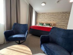霍宁斯沃格Arctic Hotel Nordkapp的一间卧室配有一张床和两把椅子